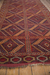 Multi-paneled red field of an antique Beshir runner with inverted navy blue and gold medallions.