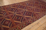 Close-up of antique Beshir runner's geometric panels, navy, red, gold inverted concentric medallions and border.