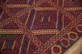Beshir rug detail: cherry red and navy multi-paneled design with gold geometric motifs.