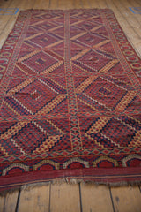 Geometric diamond motifs in brick red, navy, and pale gold on an antique Beshir runner.