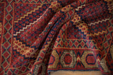 Detail of antique Beshir rug's geometric concentric medallions, brick red, navy, gold.