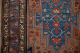 Detail of a vintage Malayer rug's serrated pattern in dusty rose, sky blue, and ivory.