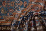 Draped folds of a vintage Persian runner showing its detailed boteh and pinwheel patterns.