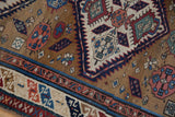 The rainbow-filled serpent border and ochre field of a hand-knotted antique Caucasian runner.