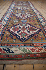 Low-angle perspective of an antique Caucasian runner showing its elongated geometric design.