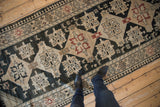 A person's view standing on the vintage Karabagh runner, showing its scale and geometric design.