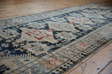 A low angle highlights the even, short pile of this vintage distressed Karabagh runner.