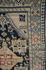 Detail of hand-knotted pictorial animals and the pawn design border on a vintage Karabagh rug.