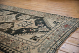Low angle view of the distressed Karabagh rug's reciprocating pawn design border and short pile.
