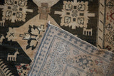 Folded corner on a vintage Karabagh rug revealing the short pile and hand-knotted foundation.