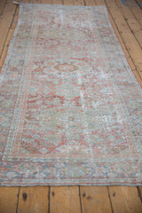 Close-up of the distressed Mahal rug texture, showing pale terra cotta and dusty blue floral motifs.