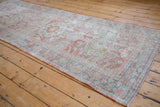 Visible wear on distressed floral Mahal runner with pale terra cotta selvage.