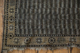 Distressed Anatolian runner's tattered fringe, geometric starburst border, and worn parallel channel motif.