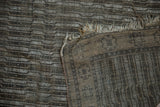 Distressed Anatolian rug showing visible light foundation, tattered fringe, and reverse side texture.