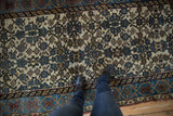 Distressed Kurdish Bijar rug showing worn Herati motif on ivory field with visible foundation.