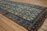 Distressed ivory field with Herati motifs, beside a geometric cartouche border.