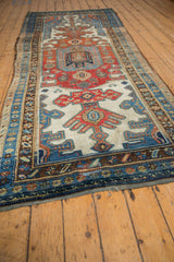 Multi-tiered border patterns in madder red, sky blue, and ivory with distressed edge wear.