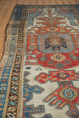 Distressed side of antique Kurdish runner, showing geometric borders in blue, red, and ivory.