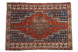 Vintage Hamadan rug with a stepped geometric diamond medallion in brick red, navy blue, and beige.