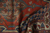 A draped vintage Persian Hamadan rug showing the texture of its worn pile and geometric motifs.