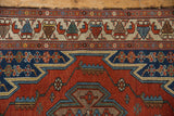 Close-up view of the tattered edge and serrated leaf border on the vintage Persian Hamadan rug.