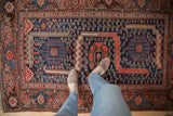 Hand-knotted Malayer rug's navy blue field and fuchsine red border with Herati and samovar motifs.