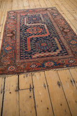 Vintage Malayer rug corner, with navy blue field, blush border showcasing samovar turtle motifs and fringe.