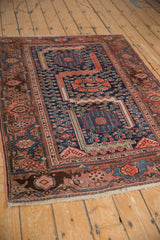 Vintage Malayer rug: navy field, blush triple medallion, stylized serpents, classic Herati border.