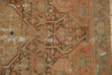 Distressed Malayer rug close-up: worn Herati pattern, blush and bronze tones, foundation visible.