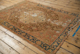 Textured vintage Malayer rug detail revealing Herati motif, faded vinery, indigo border, visible foundation.