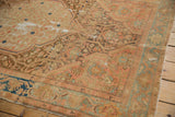 Decorative distressed Malayer rug with visible foundation, faded blush, bronze, and indigo patterns.