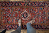 Hand-knotted Heriz rug with sprawling geometric blossoms in brick red, navy, and sky blue.