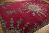 Vintage Khorassan carpet's cherry red field, intricate floral forms, and traditional patterned border.