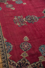 Ornate floral bud finial motifs in navy, sky blue, and ivory on a cherry red Khorassan field.