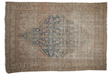 Distressed vintage Malayer rug with blue Herati medallion, worn beige field and palmette border.