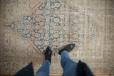 Distressed Persian Malayer rug with faded sky blue Herati, showing threadbare spots and worn pile.