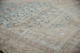 Distressed Malayer rug texture with sky blue Herati motifs on beige, foundation visible.