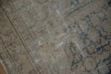Faded beige and sky blue Herati patterns on a distressed vintage Malayer rug with exposed foundation.