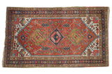 Vintage Persian Heriz rug, triple geometric medallion, madder root rust field, and patterns in navy, jade green, beige.