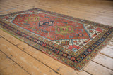 Close-up of vintage Heriz rug's rust field with geometric buds and navy seed border.