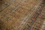Distressed Meshed rug's navy border and camel field with scrolling vinery and fuchsia blossoms.