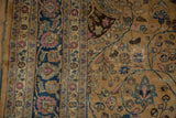 Distressed vintage Persian Meshed carpet's curvilinear pattern, camel, navy, pink, and worn.