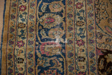 Distressed vintage Meshed carpet detail: threadbare foundation, navy blue, camel, fuchsia patterns.