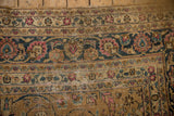Worn distressed Meshed carpet detail: camel field, navy vine border, fuchsia blossoms, exposed texture.