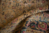 Distressed camel field with scrolling vinery and contrasting navy border with fuchsia palmettes.