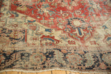 Close-up of antique Serapi rug's wide serrated leaf border and field wear.