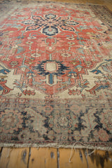 Antique Serapi carpet's threadbare foundation, worn geometric pattern, and short fringe detail.