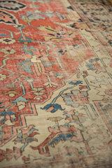 Storied wear and geometric vinery on the brick red field of this antique Serapi rug.