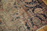 Antique Serapi carpet detail with exposed foundation, geometric vinery, and time-softened navy, brick, and ivory hues.