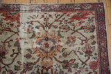 Antique Persian Mahal carpet's ivory field, time-softened terra cotta florals, and threadbare areas.